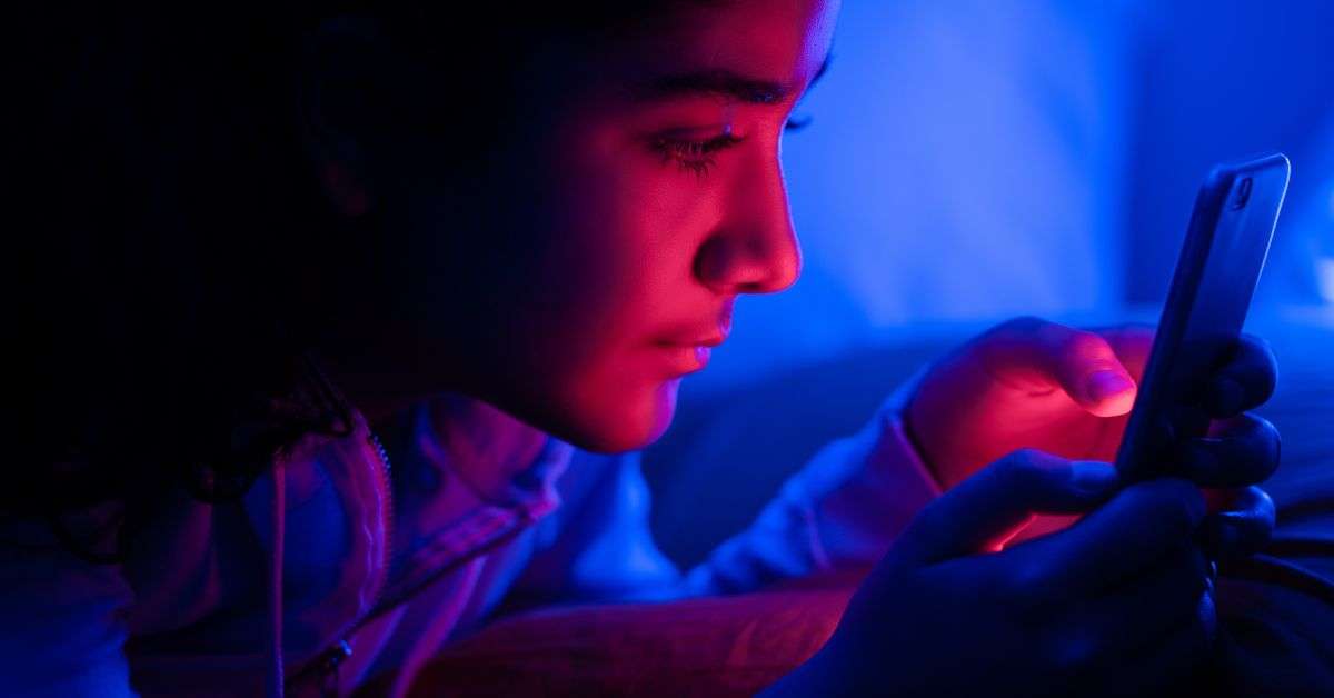 adolescente sur son smartphone pendant la nuit