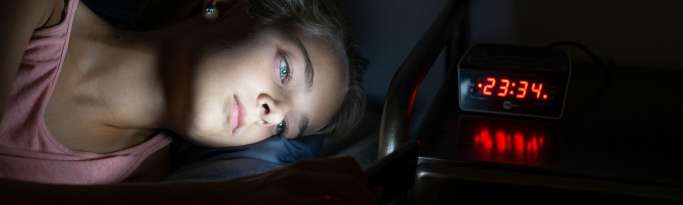 adolescent qui joue tard la nuit sur son smartphone